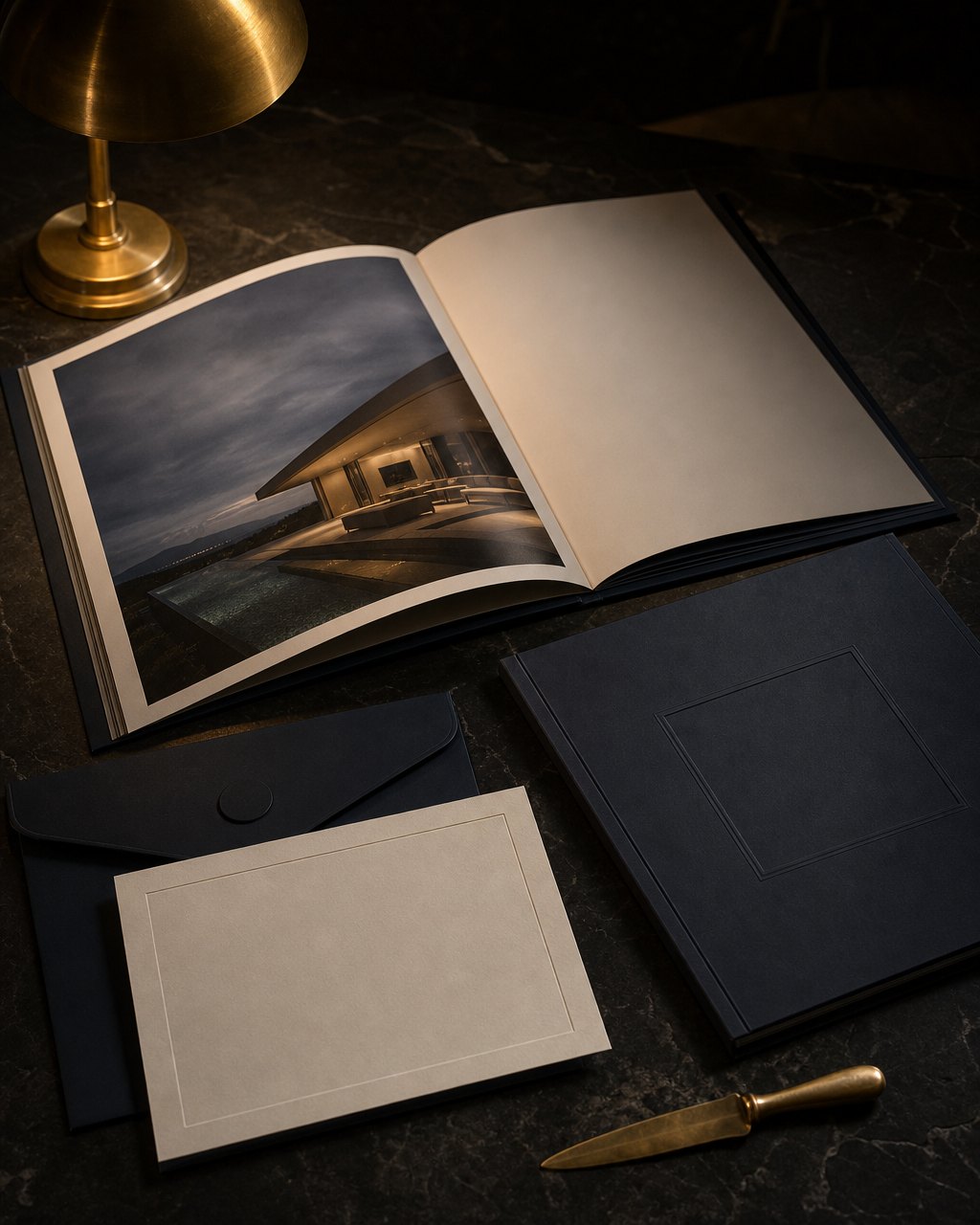 Large format luxury property brochure and mailer on a dark stone table